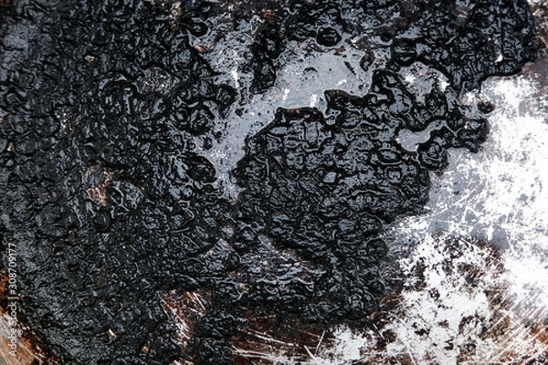 Fototapeta Burnt food in a pan. Cleaning the bottom with soot.