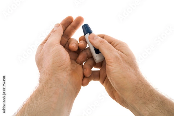 Obraz The lancing device is directed to the tip of the finger from which blood will be taken for analysis for diabetes