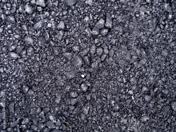Fototapeta Top view dark grey fresh new asphalt road texture with small rocks