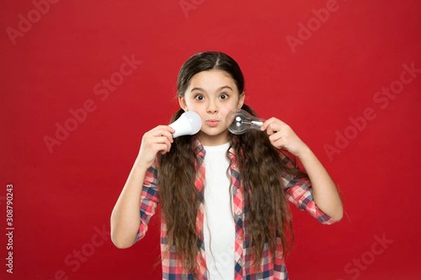 Fototapeta Energy efficient lighting. Ecology problem. Climate change. Eco life. Lighting choice. Little girl light bulbs on red background. Symbol of idea progress and innovation. Environment friendly lighting