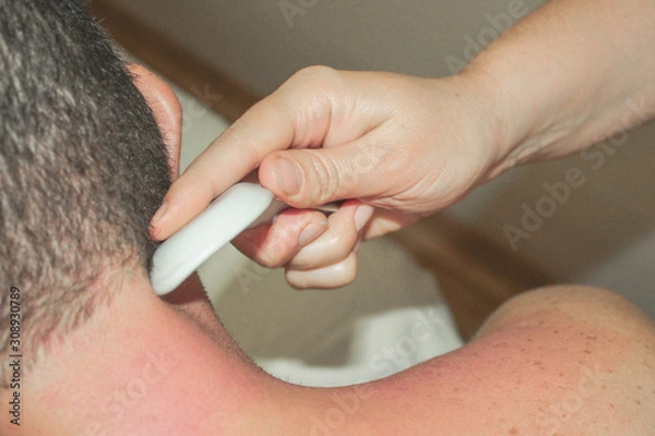 Obraz Gua sha massage. The masseuse's hands closeup. A man gets a massage.