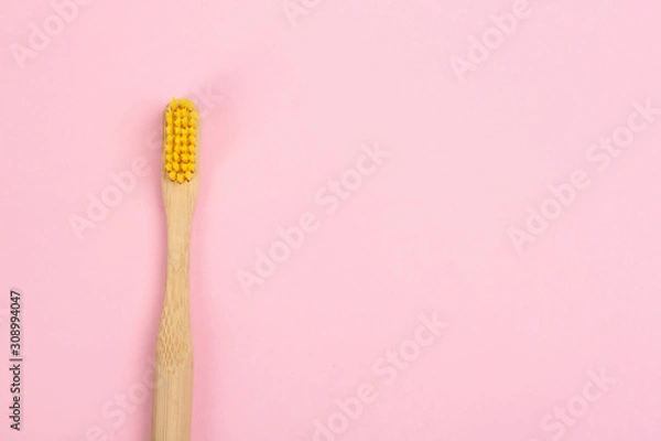 Fototapeta Toothbrush made of bamboo on pink background, top view. Space for text