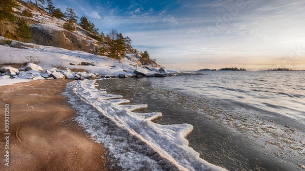 Obraz The first ice  off the coast on the water in Lake Ladoga at dawn with fresh snow in winter