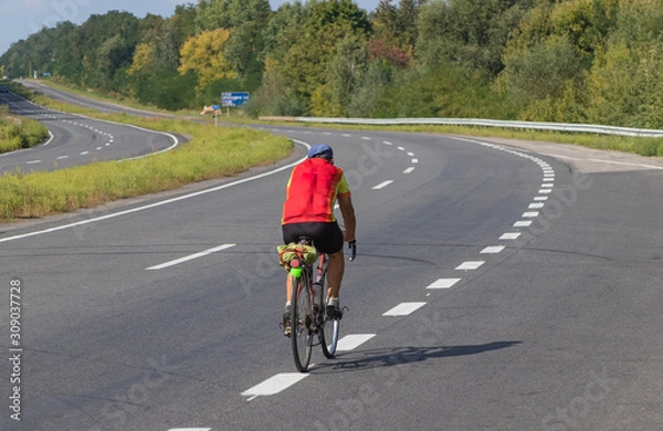 Obraz Cyclist rides on the highway on a bicycle