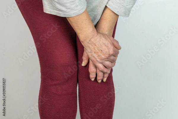 Obraz older woman with both hands on her knee, isolated on White background