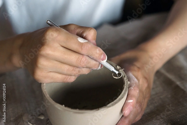 Fototapeta Female hands hold a bowl for casting clay products. Shaped method for making clay dishes. Handwork. Pottery making