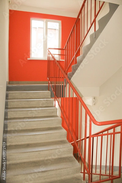 Obraz Light from the window on the stairs in a new multi-storey building. Clean entrance, orange color