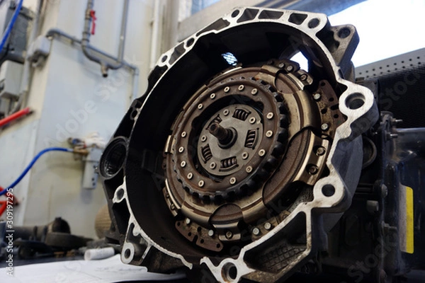 Fototapeta The DSG automatic gearbox lies on the desktop prepared to replace the clutch kit. Service, repair, spare parts for a modern car. Modern technologies in the manufacture and repair of a car. Workshop.