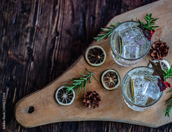 Obraz Ideas of winter drinks from gin and tonic for the new year. A bottle of gin and water tonic on a wooden table