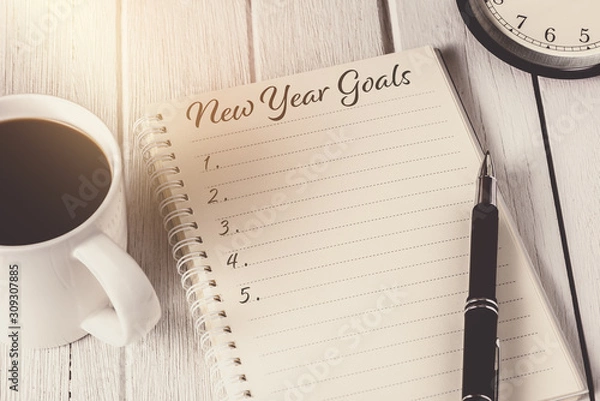 Fototapeta New Year's Goals List written on Notebook with alarm clock, pen, coffee