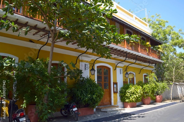 Fototapeta Yellow bright building with lanterns in the french colony in Pondicherry, sunny day and blue sky in Tamil nadu, India.