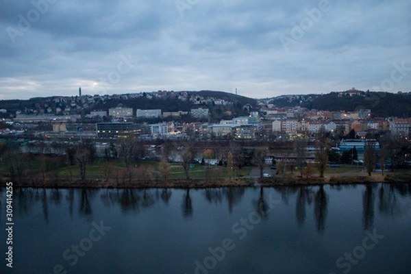 Fototapeta  Winter panorama from Vysehrad Castle to the evening city of Prague, residential areas, the Vltava River, moorings with boats and boats and city transport.