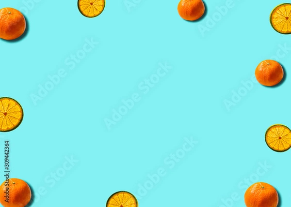 Fototapeta Flat lay citrus concept with mandarin and lemon slice on a soft blue background