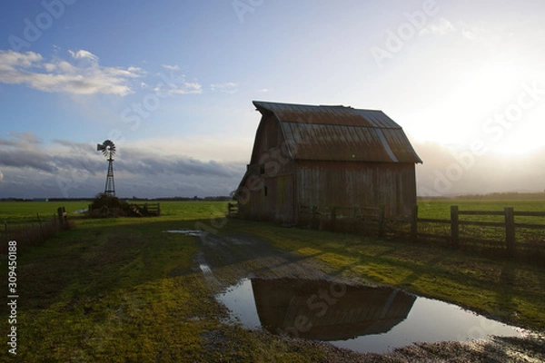 Fototapeta old barn in reflection with windmill