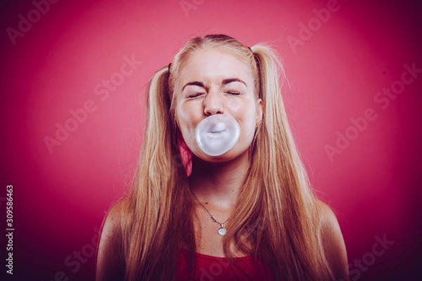 Fototapeta śliczna blond nastolatka z kucykiem wysadza gumę do żucia