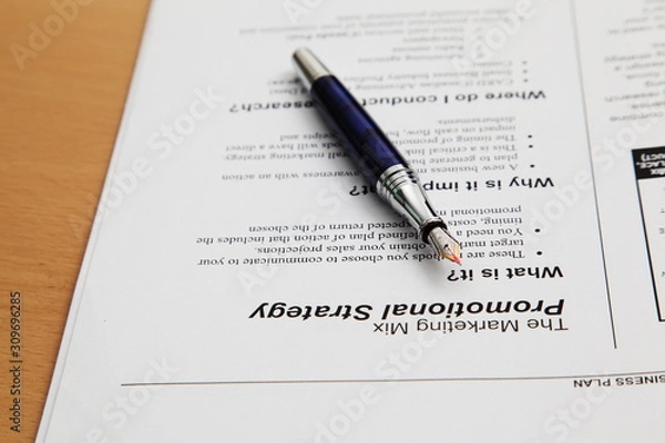 Fototapeta Business plan completed with pen and notebook 