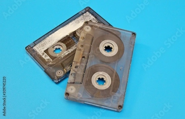 Fototapeta Plastic transparent audio cassettes located on a blue background