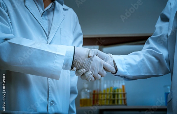 Obraz Naukowcy podają sobie ręce, aby symbolizować wspólne badania i eksperymenty