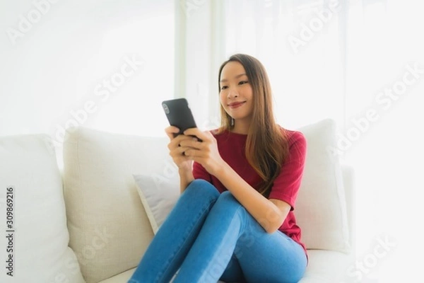 Fototapeta Portrait beautiful young asian women using mobile or smart phone on sofa