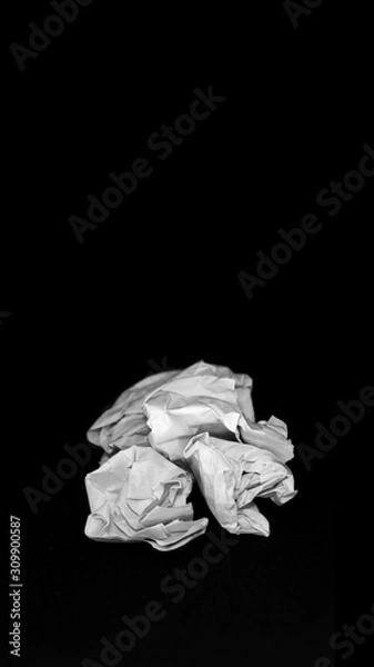 Fototapeta Crumpled sheet of paper stacking ,isolate with black background. Groups crumpled paper on black background. Crumpled paper bills in middle position. Crumpled paper ball isolated on a black background