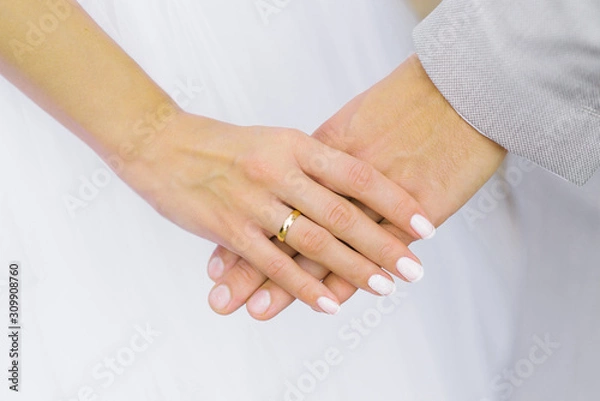 Fototapeta The bride holds the hand of the groom. Wedding engagement ring on your finger