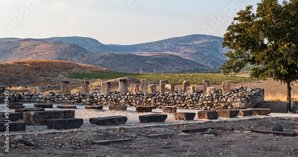 Fototapeta ruins of an israelite stone storehouse made with pillars and columns at the tel hazor archaeological park in israel with the canaanite city and kibbutz ayelet shahar in the background