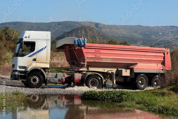 Obraz Heavy lorry or truck drives through small river