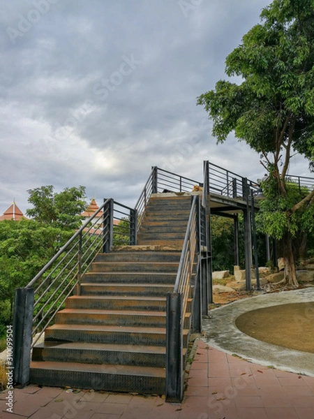 Obraz The long steel stairs up the hill in the park at the time of overcast clouds.