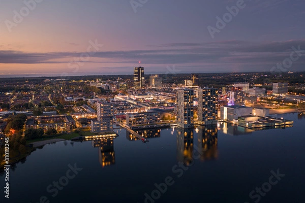 Obraz Almere city center illuminated at dusk. Aerial view.