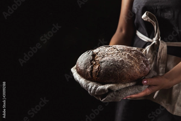 Obraz rustic bread in baker hand, healthy food