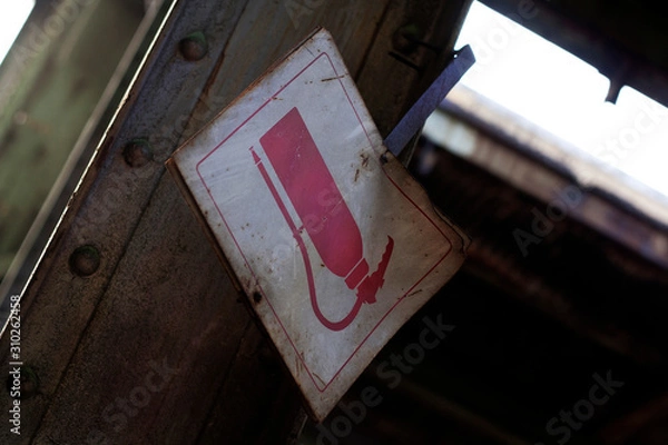 Obraz Old rusty falling fire extinguisher sign