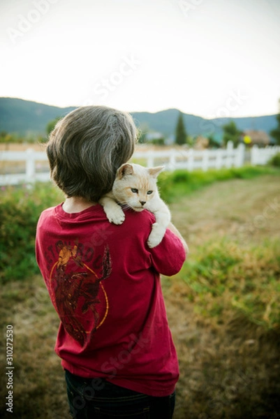 Obraz Person holding cat on a farm