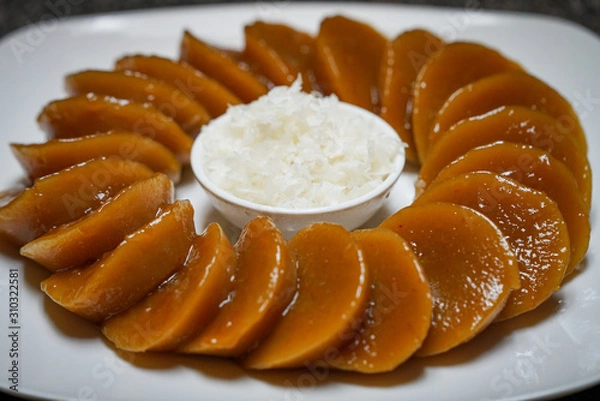 Obraz Closeup view of homemade Filipino dish Kutsinta with coconut flakes on a white plate
