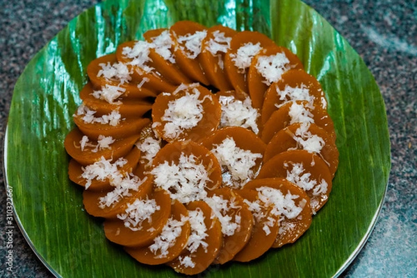Obraz Closeup view of homemade Filipino dish Kutsinta with coconut flakes served on banana leaf