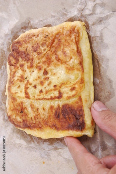 Fototapeta Hand hold  murtabak on paper parchment