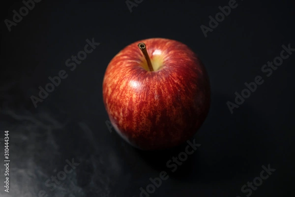 Obraz Red apples placed on a black leather floor