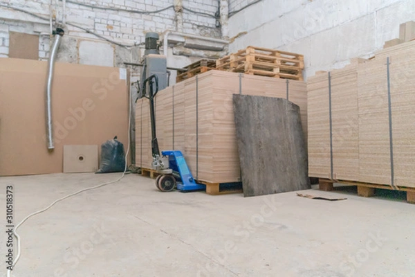 Fototapeta a lot of wooden sheets stacked on a wooden pallet in a warehouse, industrial premises