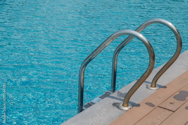 Fototapeta Stairs Ladder and handle down the swimming pool with blue water