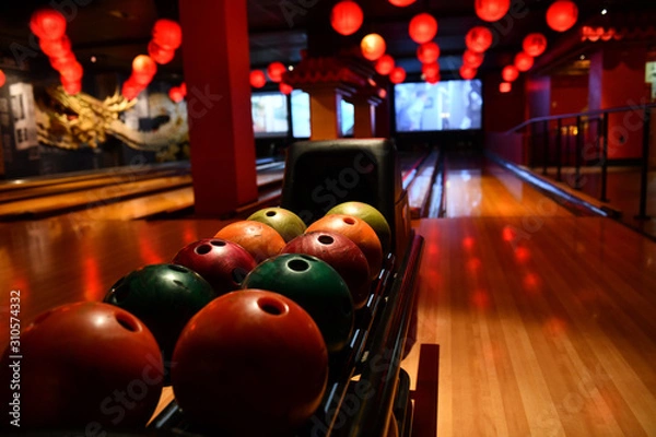 Fototapeta Bowling lane and balls in the row in bowling center.