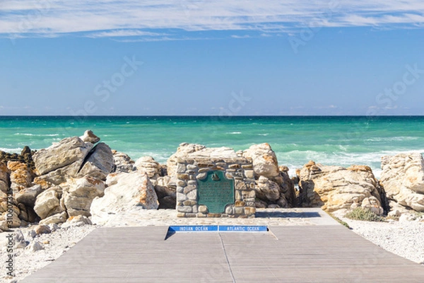 Fototapeta The survey marker and ikon of Cape Agulhas (also known as Cape of the Needles) - the southern-most tip of Africa, rocky coastline where Atlantic and Indian Oceans meet