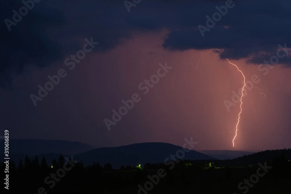 Fototapeta Thunderstorm with lightning on the mountain.