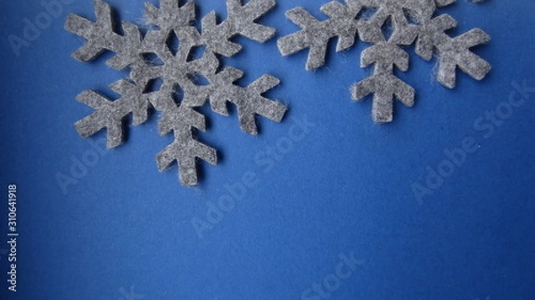 Fototapeta  Two grey felt snow stars on a blue background. Flat lay.  Creative Christmas card idea