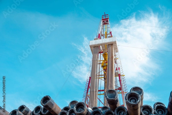 Obraz Oil and Gas Drilling Rig onshore dessert with dramatic cloudscape. Oil drilling rig operation on the oil platform in oil and gas industry.