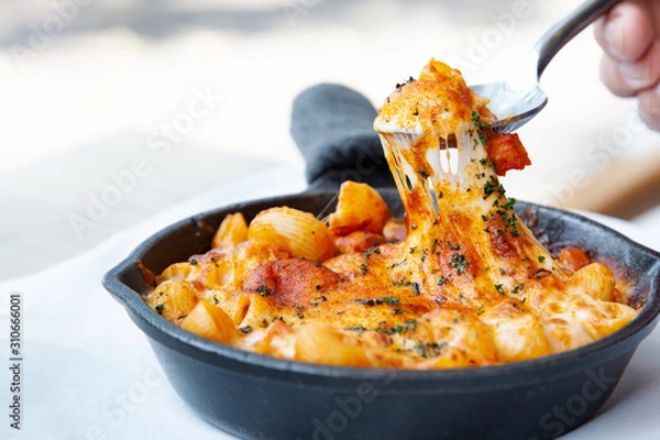 Fototapeta Baked macaroni and cheese with fresh tomato sauce served on hot pan