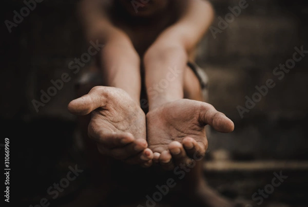 Fototapeta poor child or beggar begging you for help sitting at dirty slum. concept for poverty or hunger people,human rights,donate and charity for underprivileged children in third world 