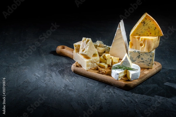 Fototapeta Different sorts of cheese. Cheese platter with different cheese, and spices on dark background. Top view, wiht copy space