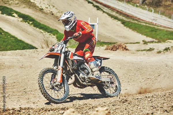 Fototapeta Close-up of mountain motocross race in dirt track in day time. Concept focus of during an acceleration in action sport
