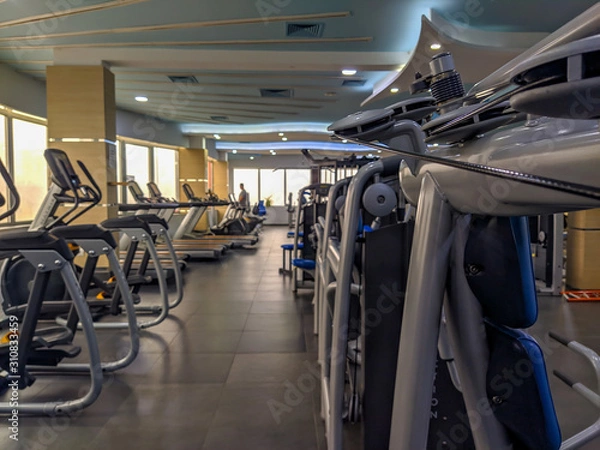 Fototapeta Modern gym equipment interior for weight loss and more healthy and active life for increasing strength and endurance