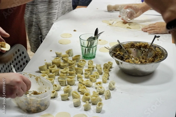 Fototapeta the dumpling making or eyelet with mushrooms and cabbage for Christmas table beet soup on the Wigilia god born in Poland. group of people work, new year activity