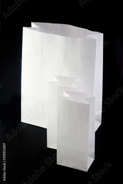 Fototapeta  three white eco paper bags for products on a black background